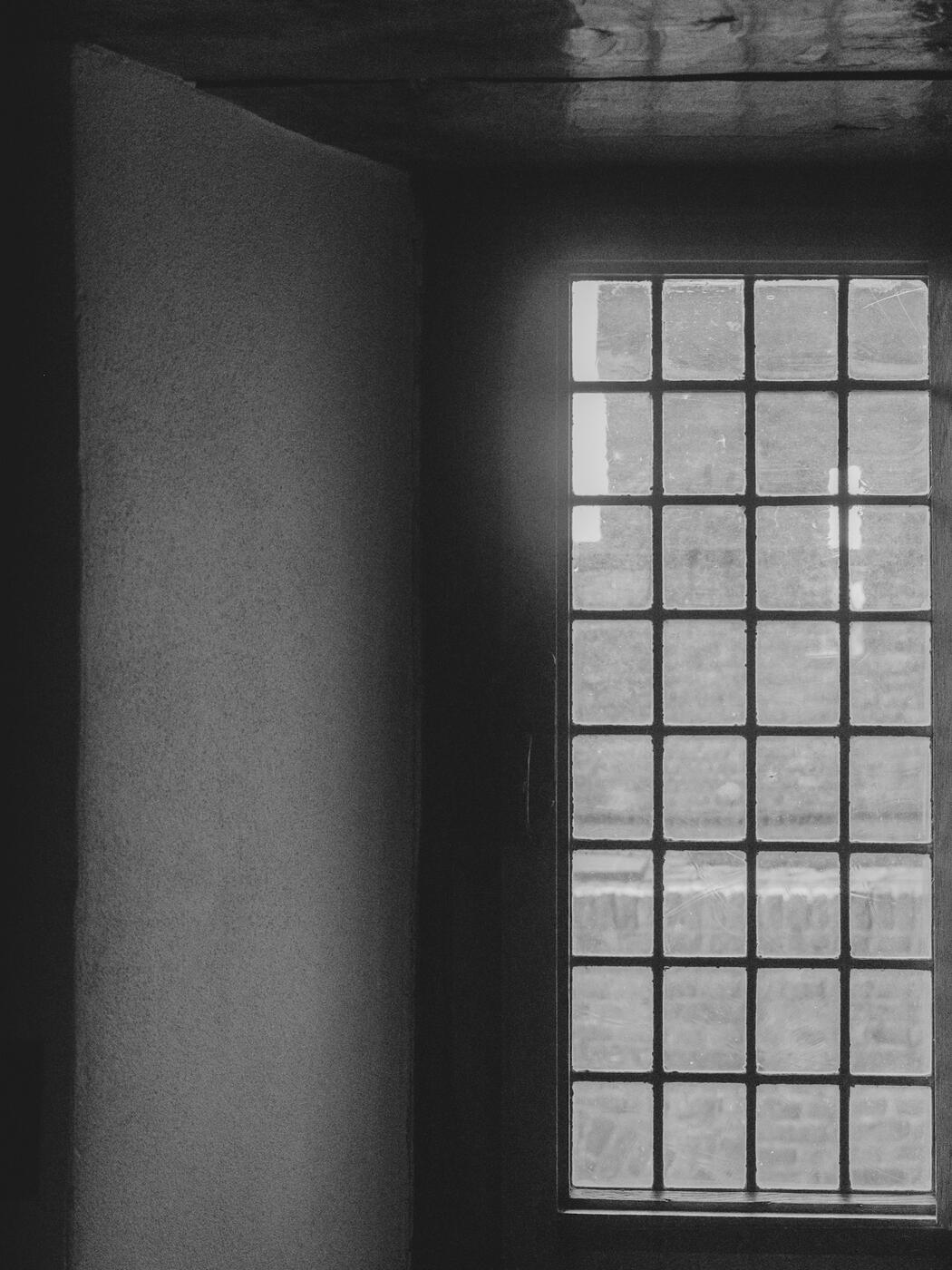Light through a gridded window in a dark interior